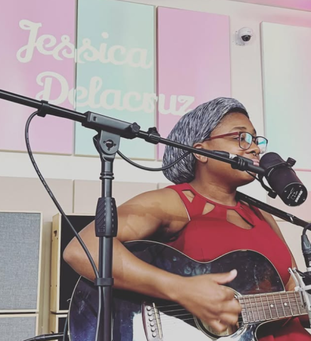 Jessica Delacruz Playing a Guitar in front of a microphone