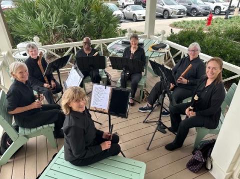 seated musical group holding recorders