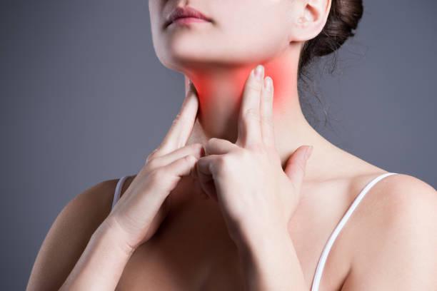 woman pressing her fingers to her neck